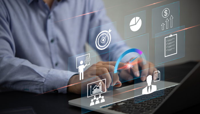 A man touching an image of 6 business tools floating above his laptop.