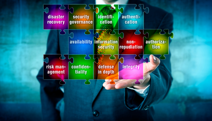 Multicoloured jigsaw puzzle pieces with words floating over a man in a blue dress suit.