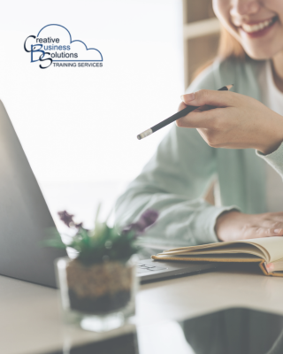 A woman holding a pencil pointing it at a laptop screen.